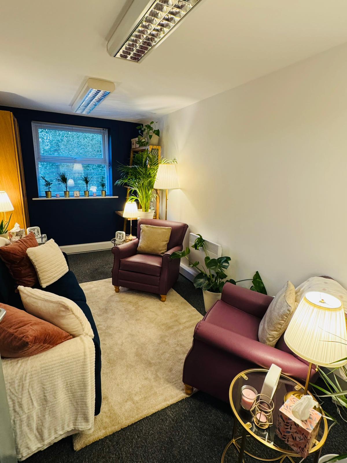 Counselling room with armchairs, sofa and warm lighting